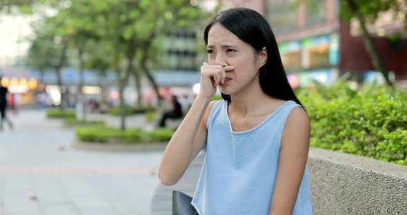Woman sneeze and cough at outdoor in Hong Kong city 