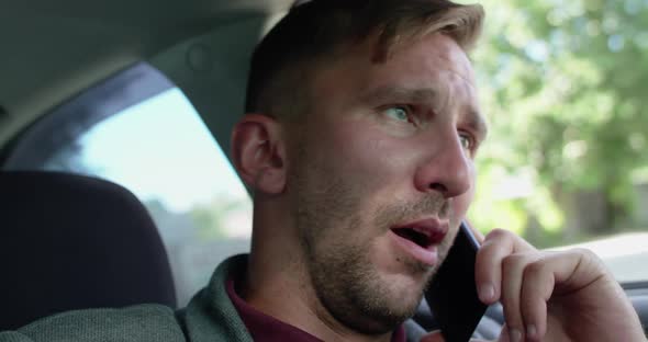 Portrait of Man Receives a Phone Call with Yawning in the Car and Nods a Head