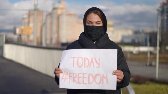 Front View Portrait of Young Caucasian Woman in Covid Face Mask with Freedom Today Placard in