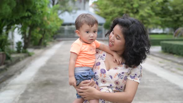 Happy Mother and Baby Son Bonding Together Outdoors