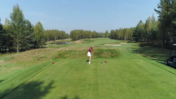 Summer Day Woman Playing Golf Hits the Ball Aerial View of Golf Course in Forest Area Green Lawn