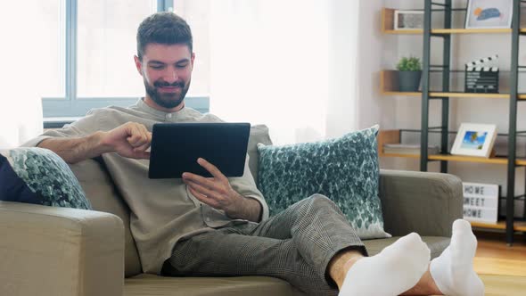 Smiling Man with Tablet Computer at Home