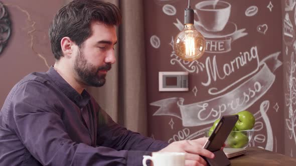 Bearded Young Man Using His Tablet To Have a Video Chat