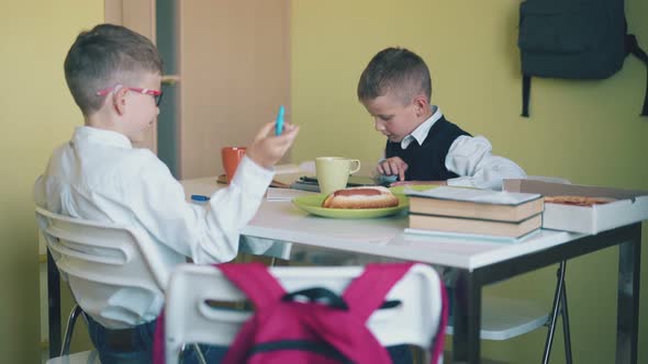 Primary School Students Rest at Table with Fastfood in Room