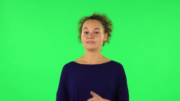 Portrait of Curly Woman Listening Attentively and Nodding His Head Pointing Finger at Viewer. Green