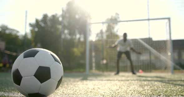 Closeup of Ball on the Field While Man Standing at Soccer Net