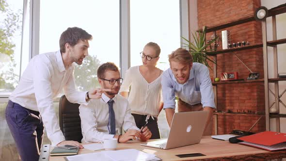 Two Male Businesmen and Female Secretary Standing Around Boss in White Shirt and Glasses Discussing