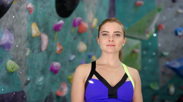 Confident Caucasian Female Climber Posing next to Indoor Walls