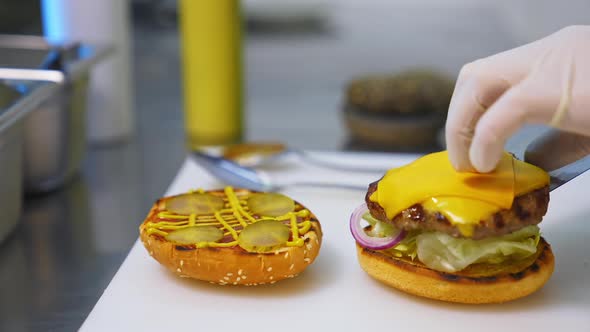 Burger restaurant menu cooking process. Chef hands preparing delicious hamburger with beef cutlet