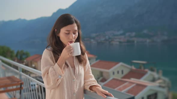 Young Inspired Asian Woman Standing Terrace Enjoying Drinking Hot Coffee Tea Watching Views of