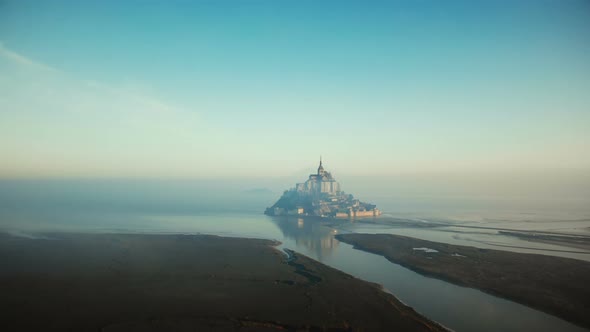 Atmospheric Cinematic Aerial Shot of Foggy Sunrise Mont Saint Michel on High Tide, Famous Island