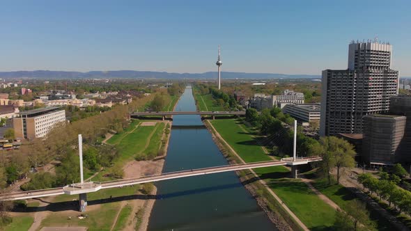 Top view of the embankment of the Neckar River. Bridges, TV tower, green grass and trees.