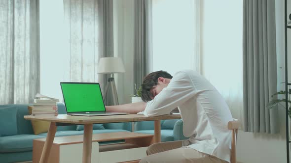 Side View Of Asian Man Student Sleeping While Using Green Screen Computer At Home