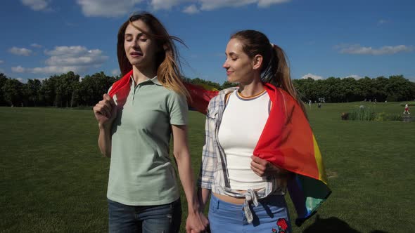 Happy Girlfriends with Lgbt Flag Walking on Lawn