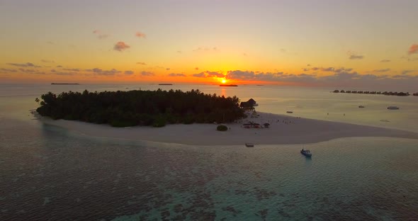 Aerial drone view of a scenic tropical island in the Maldives at sunset