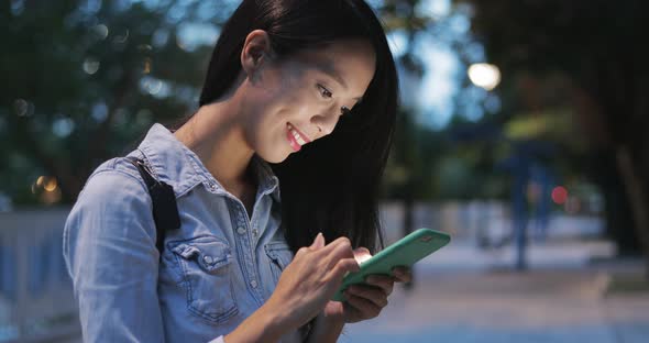 Woman looking at mobile phone in the evening