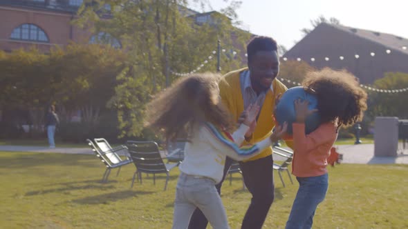 African-american Father Playing with Daughters in Summer Park