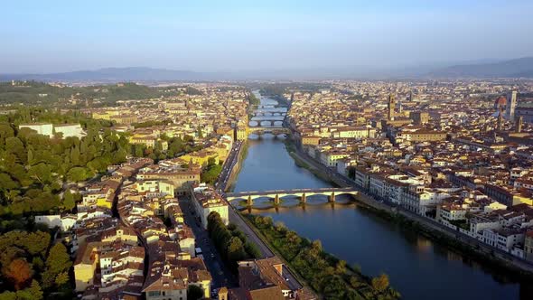 Arno River and bridges like Ponte Vecchio in the city of Florence Italy, Aerial pedestal lift shot