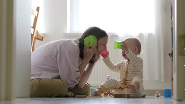 Little Baby Girl and Mommy Play with Colorful Toys at Home Sitting on Floor