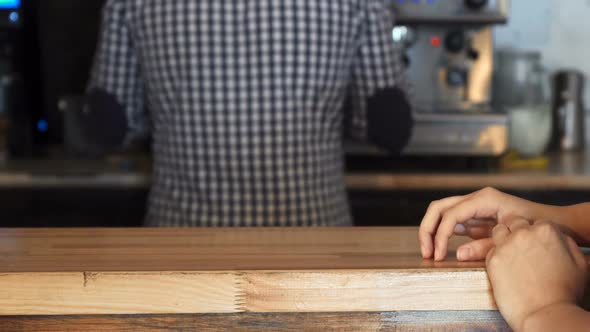 The Barista Gives the Client an Order