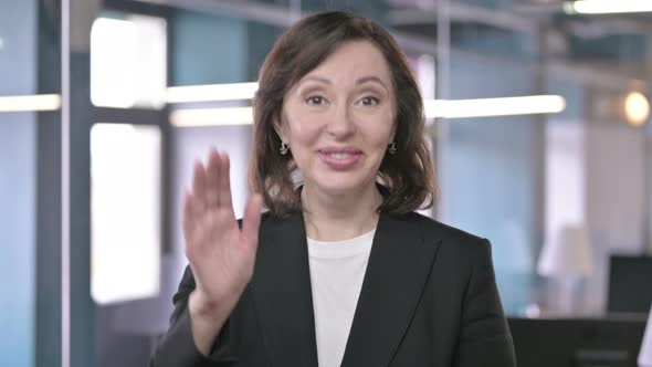 Portrait of Cheerful Middle Aged Businesswoman Waving at Camera and Welcoming