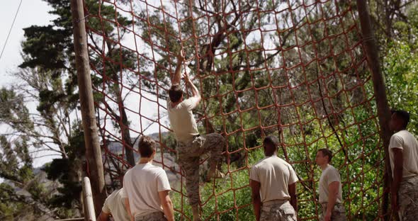 Military troops climbing a net during obstacle course 4k