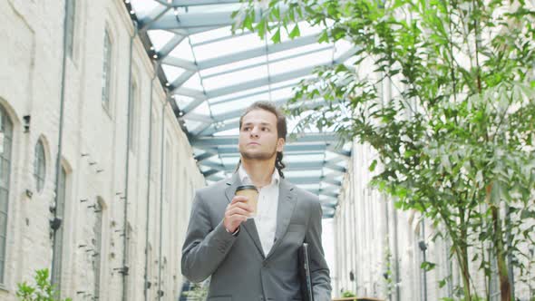 A young successful businessman is walking down the street. Man in a casual wear.