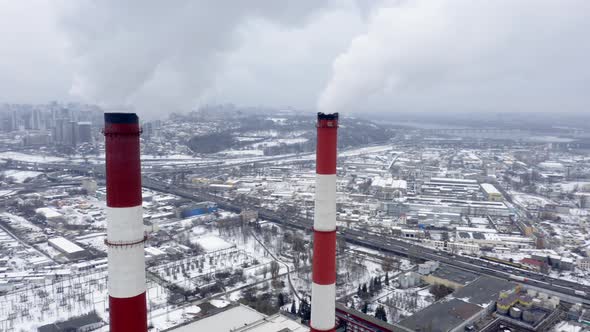 Winter View of a Big Modern Industrial City with Two Tall and Heavily Smoking Factory Pipes alt