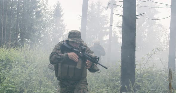 Soldiers in the Smoke Moving in Battle Operation Through Dense Forest