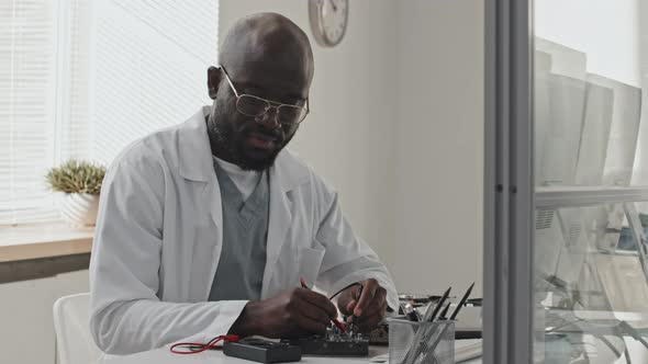 Portrait of African American Engineer with Multimeter in Lab