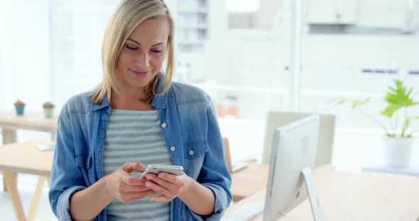 Businesswoman text messaging on mobile phone