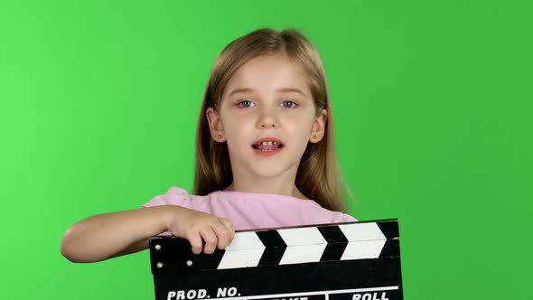 Baby Holds in Hands Clapperboard. Green Screen