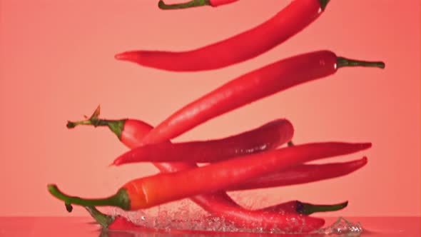 Super Slow Motion Ripe Chili Pepper Falls on the Water with Splashes