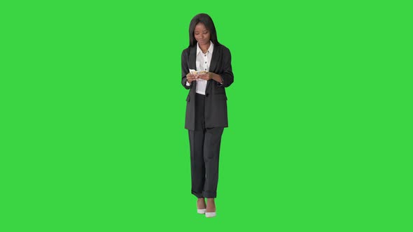 Happy African American Woman Counting Money While Walking on a Green Screen, Chroma Key