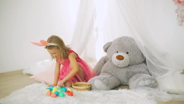 Little Girl Counting Colorful Easter Eggs at Home