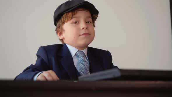 Child Boy Entrepreneur Works in the Office Sitting at the Table