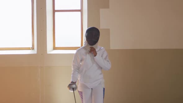 Female fencer athlete during a fencing training in a gym