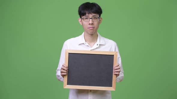 Young Asian Businessman Holding Blackboard