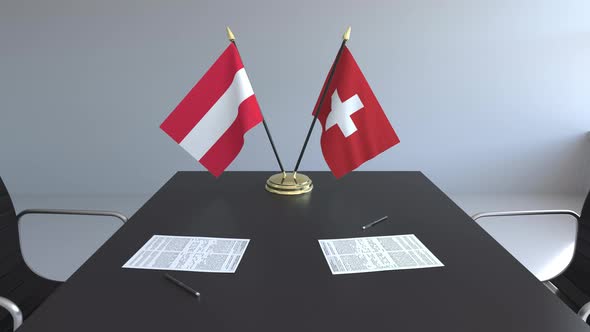 Flags of Austria and Switzerland and Papers on the Table