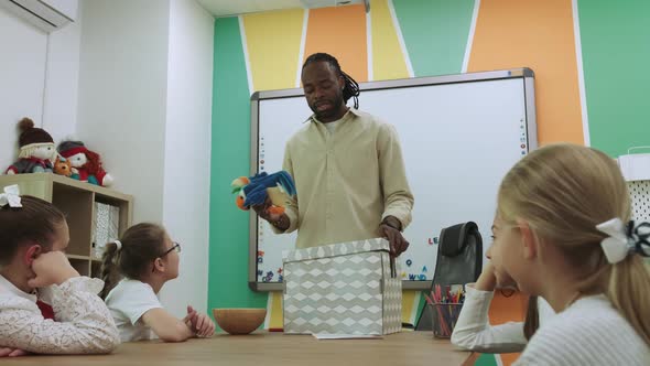 An African American Teacher Teaches a Group of Children English By Playing with Them