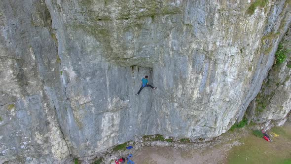 Aerial view of a man rock climbing up a mountain