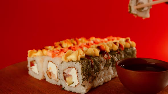 Person eating sushi with chopsticks.