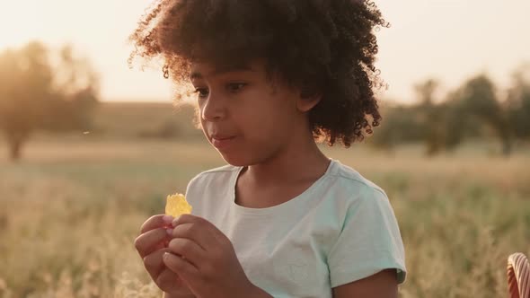 An afro-american girl is eating cheese