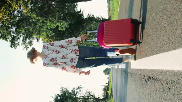 Cheerful Girl with Suitcase Walking on Road.