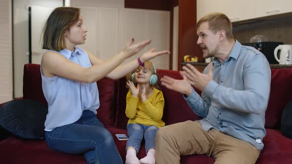 Child Girl Trying To Be Distracted and Not Hear Quarrels Between Parents at Home. Family Problems