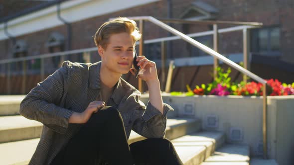 Young Man Calling on Smartphone on Roof Top