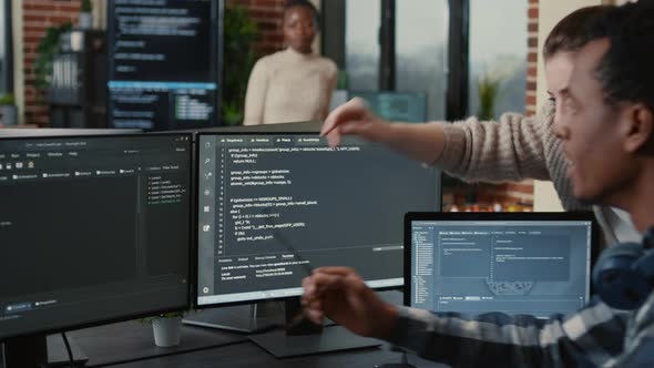 Software Developer Looking at Running Code on Multiple Screens Takes Off Glasses and Doing High Five