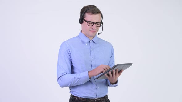 Young Annoyed Businessman As Call Center Representative Using Digital Tablet