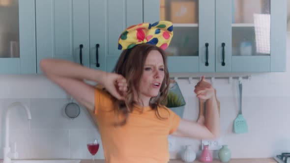 A Beautiful Woman in White Shorts is Relaxing at Home Dancing in the Kitchen