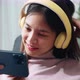Woman sitting on sofa with holding the smartphone to watch movies on mobile application. - VideoHive Item for Sale